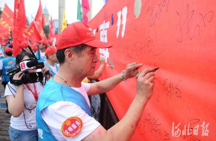 1.志愿服务者代表在条幅上签名。记者孙也达摄.jpg