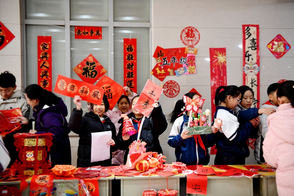 2025年12月31日，学生们在河北省石家庄市栾城区兴安大街小学举办的校园年货大集上交换新年饰品。 (14).jpg